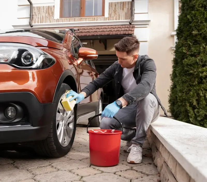 Lavage auto à domicile Saint-Silvain-Bas-le-Roc : professionnel intervenant sur un véhicule